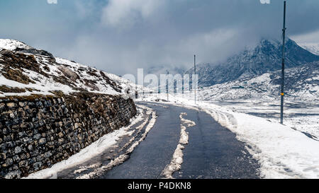 Curvy hillside road of kupup, East Sikkim, India . covered with snow and clouds. Stock Photo