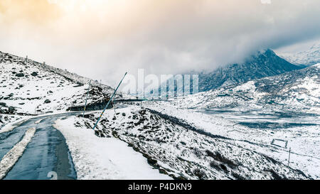 Curvy hillside road of kupup, East Sikkim, India . covered with snow and clouds. Stock Photo
