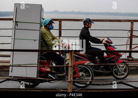 Hanoi, Vietnam - March 15, 2018: Vietnamese man transporting an enormous fridge on his motorbike Stock Photo