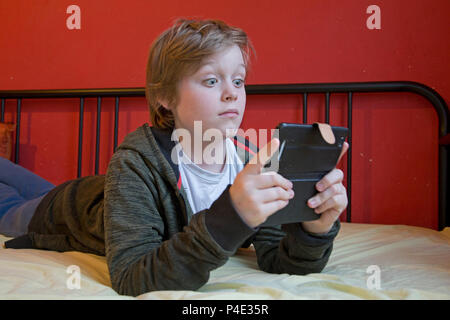 underage boy seeing something disturbing on the Internet on his smartphone Stock Photo