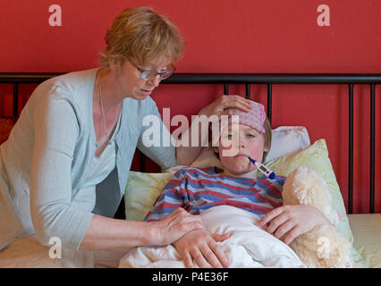 mother comforting her ill son in his bed