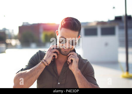Happy young man smile and holding headphones outdoor portrait Stock Photo