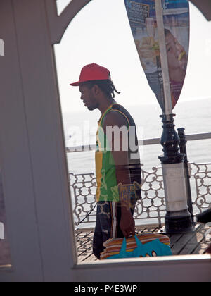 A stroll on Brighton Pier with a bag of towels Stock Photo