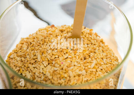hazelnut sprinkles in a large glass jar for sprinkling on ice cream or other desserts Stock Photo