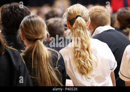 high school teenage students boys and girls in uniform sitting listening at assembly or presentation. Teaching, learning, teacher, education education Stock Photo