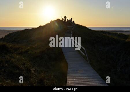 People on a high dune on the island Amrum near Norddorf watching the warm light during sunset above the sea, 11 May 2018 | usage worldwide Stock Photo