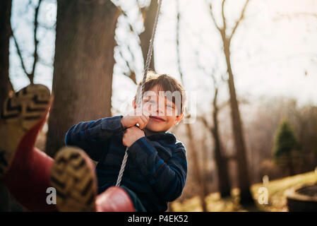 Portrait of a smiling boy on a swing Stock Photo