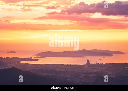 View of silhouette landscape with Kota Kinabalu city against islands at golden sunset.  Sabah state, Malaysia. Stock Photo