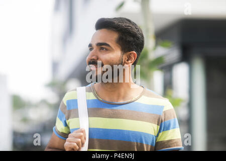 Portrait of a man standing in street looking sideways Stock Photo