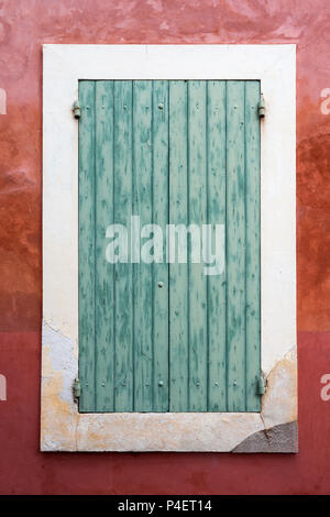 very old green painted shutters on window in medieval french house in provence Stock Photo