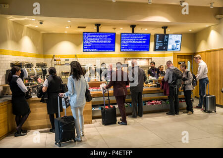 People buying fast food at counter with Windows blue screen on monitors, Heathrow, London airport, UK Stock Photo