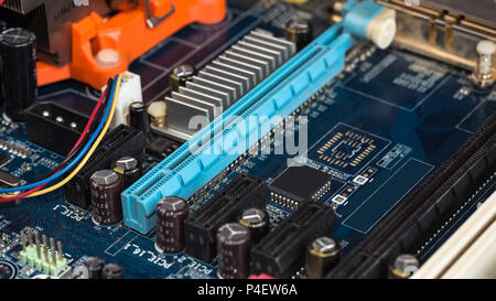 Motherboard with visible PCI express connector slot, heat sink, memory slot, cpu socket in blue. Stock Photo