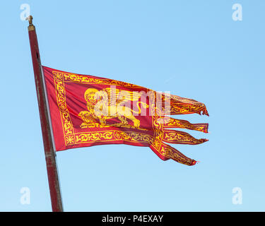 Venetian flag with Lion of St Mark  flying against a sunny blue sky, Venice, Veneto, italy Stock Photo