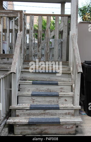 Wooden stairway leading to a wooden porch in the backyard of a standard Chicago house. Stock Photo