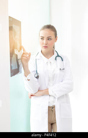 Doctors women discussion and reviewing a resonance magnetic imaging or x ray film checking skull of human head nn examination room. with copy space. Stock Photo