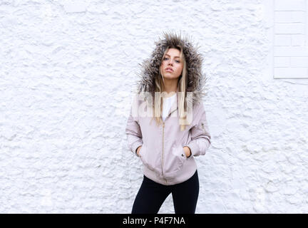 Teenage girl posing with a fur lined coat Stock Photo