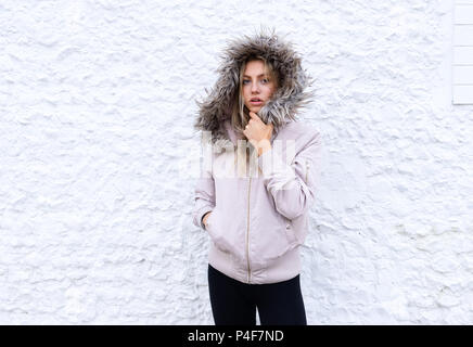 Teenage girl posing with a fur lined coat Stock Photo