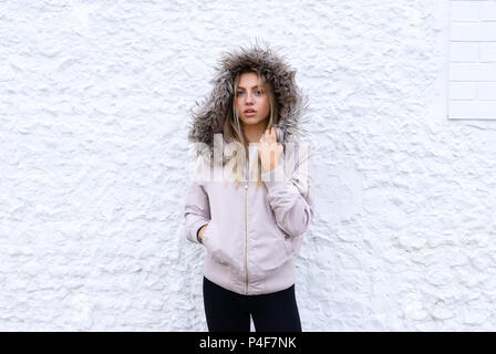 Teenage girl posing with a fur lined coat Stock Photo