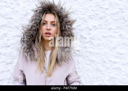 Teenage girl posing with a fur lined coat Stock Photo