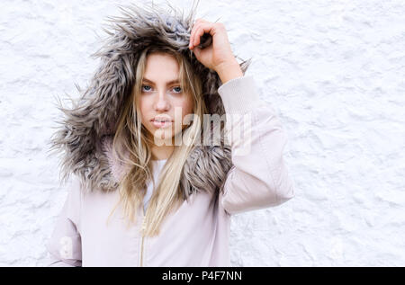 Teenage girl posing with a fur lined coat Stock Photo