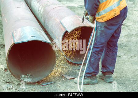 Welder worker cutting hole in metal with oxy acetylene blow torch at at building site. Vintage style. Stock Photo