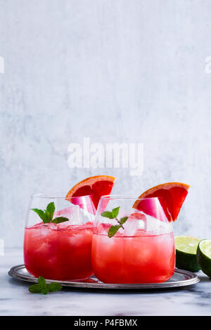 alcoholic cocktail Paloma of grapefruit and ice in glasses on a marble table . refreshing drink with lime juice Stock Photo