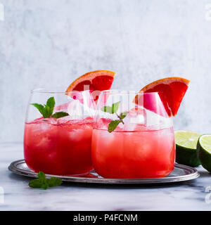 alcoholic cocktail Paloma of grapefruit and ice in glasses on a marble table . refreshing drink with lime juice Stock Photo