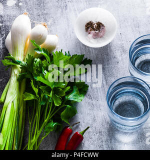 fresh greens and spices on the table. and two glasses of clean drinking water Stock Photo