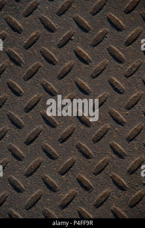 Closeup of distressed, mottled, grungy industrial checker plate rusty metal background texture with diamond pattern wallpaper for construction, heavy  Stock Photo