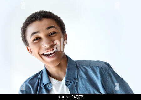 head and shoulders shot of laughing african american teen boy looking at camera isolated on white Stock Photo