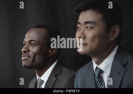 selective focus of smiling african american businessman and asian colleague Stock Photo