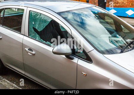 A parked car with its side window smashed Stock Photo