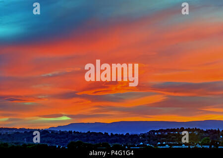 Glasgow, Scotland, UK 22nd June. UK Weather: Midsummer passes and a stunning  fiery sunrise for the beginning of summer as the gap in the Campsie fells  hills North of the city hosts a bright red start with wavy cloud formations taking on the rosy hue. Gerard Ferry/Alamy news Stock Photo