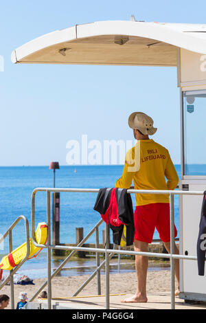Bournemouth, Dorset, UK. 22nd June 2018. UK weather: lovely warm sunny day at Bournemouth beaches as visitors head to the seaside to make the most of the sunshine, as the forecast is for temperatures to increase further. RNLI Lifeguard keeping a look out at Lifeguards kiosk hut on duty. Credit: Carolyn Jenkins/Alamy Live News Stock Photo