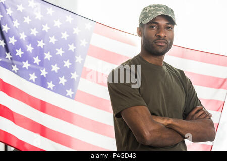 Handsome african american soldier in camouflage clothes in front of us flag Stock Photo