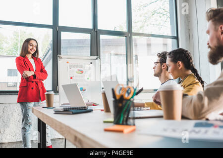 Successful business people listening to their female colleague in modern light office Stock Photo