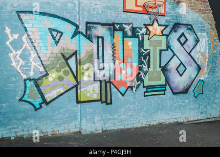 colorful graffiti on wall with basketball hoop at night Stock Photo