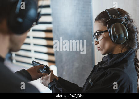 instructor describing gun to client in shooting range Stock Photo