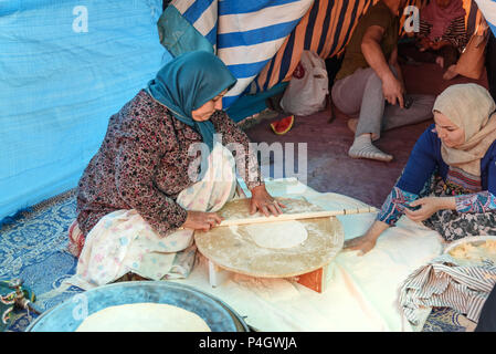 Shiraz, Iran - March 24, 2018: Iranian woman preparing traditional bread on the street market Stock Photo