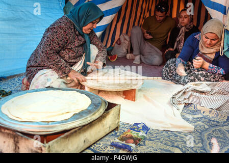 Shiraz, Iran - March 24, 2018: Iranian woman preparing traditional bread on the street market Stock Photo