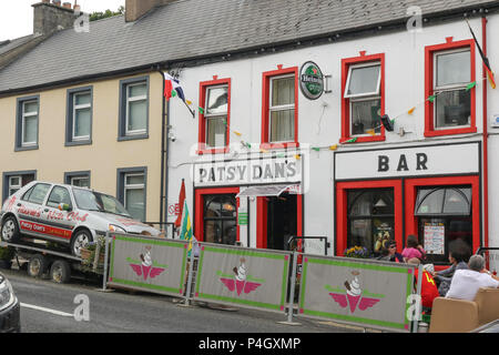 People sitting outside public house in the street in a County Donegal village - Patsy Dan's Bar Dunfanaghy. Stock Photo