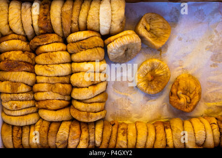 Dried figs in a box on parchment paper for transportation and sale, floral background Stock Photo
