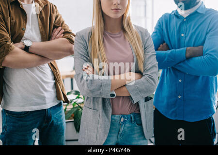 cropped shot of three business colleagues with crossed arms in modern office Stock Photo