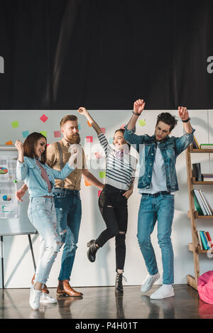 Diverse business team celebrating success in light workspace Stock Photo
