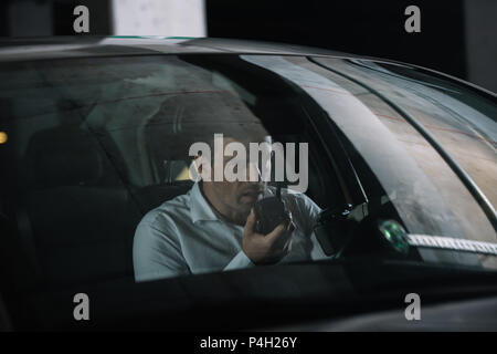 male undercover agent in sunglasses sitting in car with paper cup of coffee  Stock Photo by LightFieldStudios