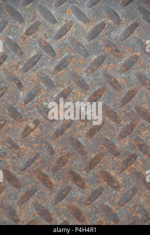 Closeup of a distressed, mottled, gungy industrial diamondplate, chequerplate rusty metal background texture with diamond grip pattern perfect for wal Stock Photo