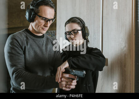 instructor describing client how to hold gun Stock Photo