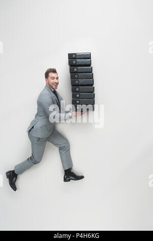 overhead view of young businessman carrying stack of folders isolated on grey Stock Photo