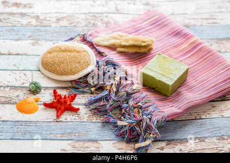 Turkish towel peshtemal with seashells, sponge, natural soap, and brush scrubber Stock Photo