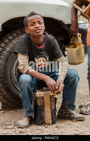 Addis Ababa, Ethiopia, January 27, 2014, Young teenager working as a shoe shine boy on the street, looking straight at the camera Stock Photo